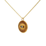 Gold necklace with textured eye medal and stone