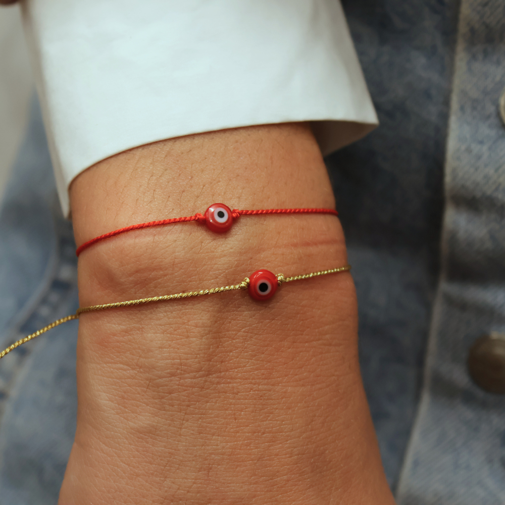 Bracelet doré sur fil fin avec oeil plat rouge