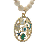 Collier médaillon doré perles en os symboles chance 90 cm