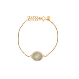 Golden bracelet with faceted oval stone and zircons