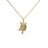 Gold necklace and turtle with cabochon stone