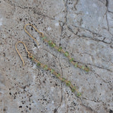 Boucles d'oreilles dorées pendantes avec peridot taillée brut