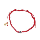 Bracelet doré sur cordon rouge avec petit oeil noir