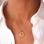 Collier doré médaille oeil texturé et pierre